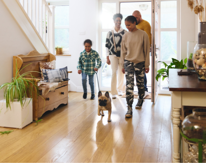 Family and their dog walking across durable hardwood flooring