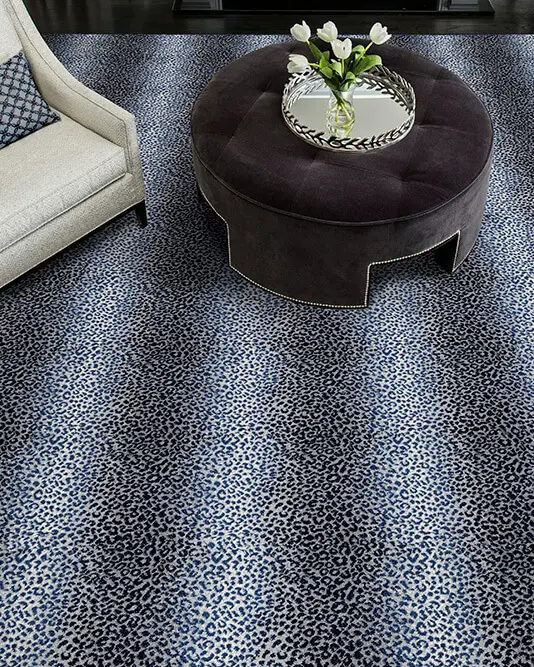 Blue leopard print carpet, velvet ottoman and textured chair.